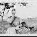 Woman carrying basket and shoes on way to market, Hungary 1923