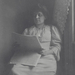 Betty Kurth reading newspaper next to window