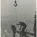 Two-workers-attaching-a-beam-with-a-crane-1931-520x722