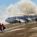 Passengers move away from the crash site of Astana flight 214, a